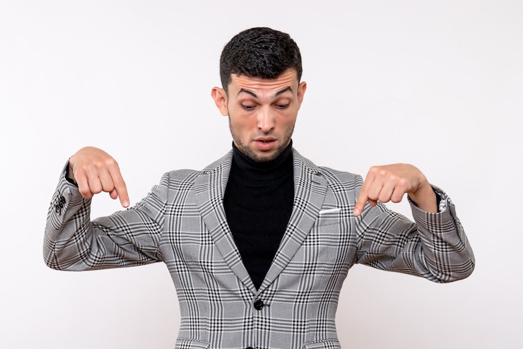 Foto grátis homem bonito de frente para o terno apontando para o pé no chão sobre fundo branco