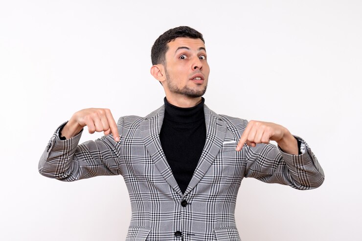 Foto grátis homem bonito de frente para o terno apontando para o pé no chão sobre fundo branco