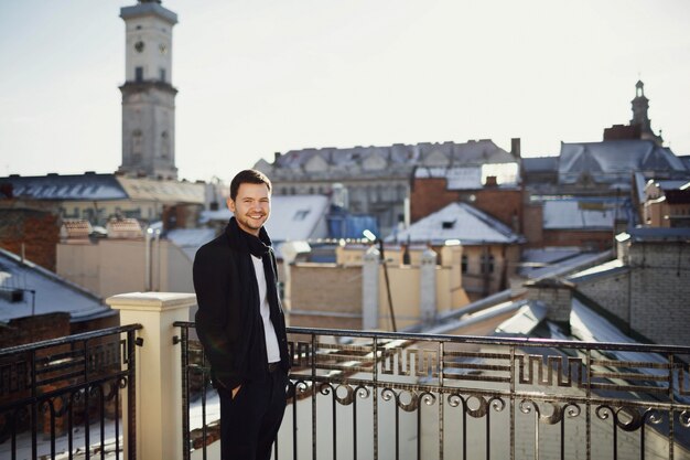 Homem bonito de pé no terraço com lindas vistas