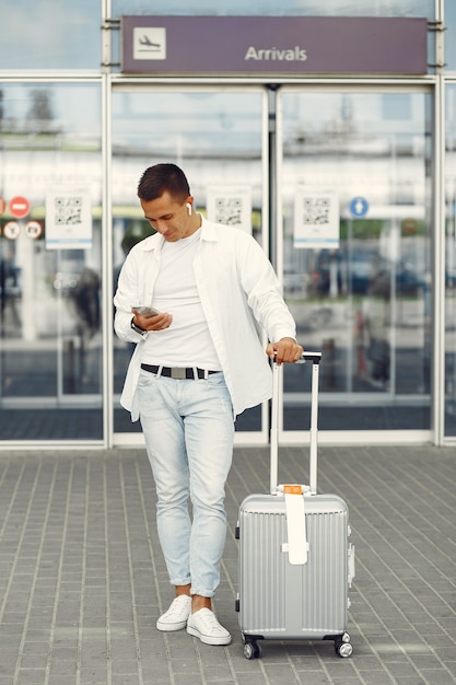 Homem bonito, de pé perto do aeroporto