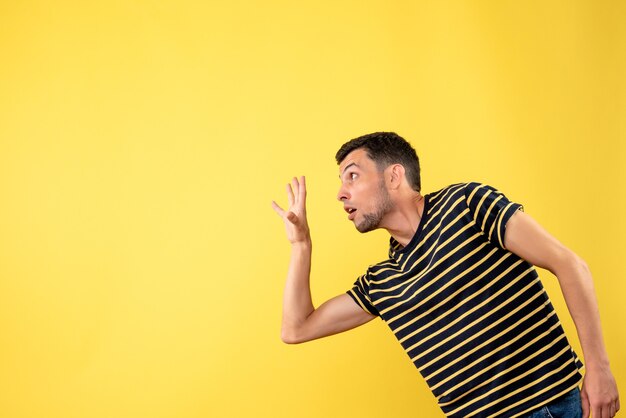 Homem bonito de vista frontal em uma camiseta listrada de preto e branco amarelo isolado de fundo