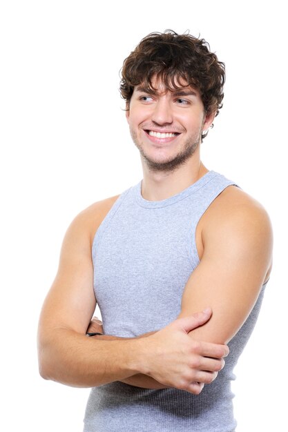 Homem bonito e musculoso com uma cara feliz e sorridente, olhando para longe - isolado no branco