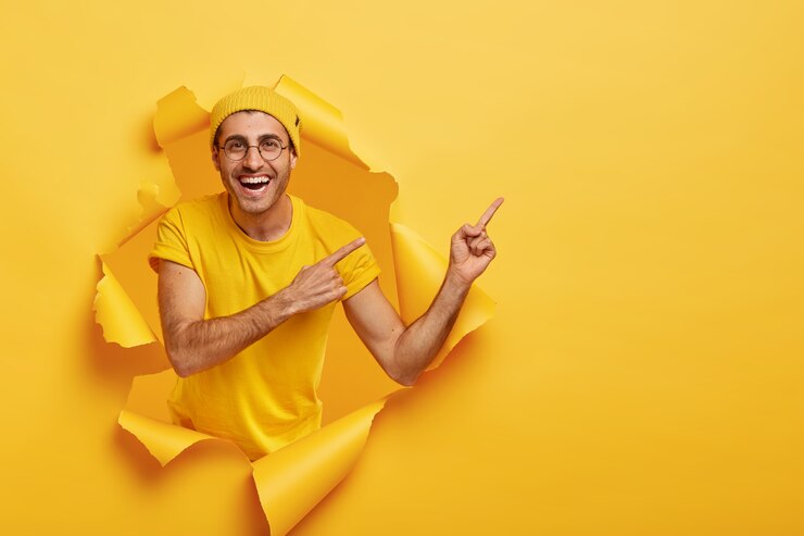 Foto grátis homem bonito e positivo posando em papel rasgado