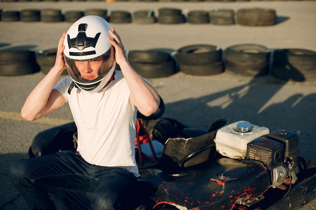 Foto grátis homem bonito em um kart com um carro