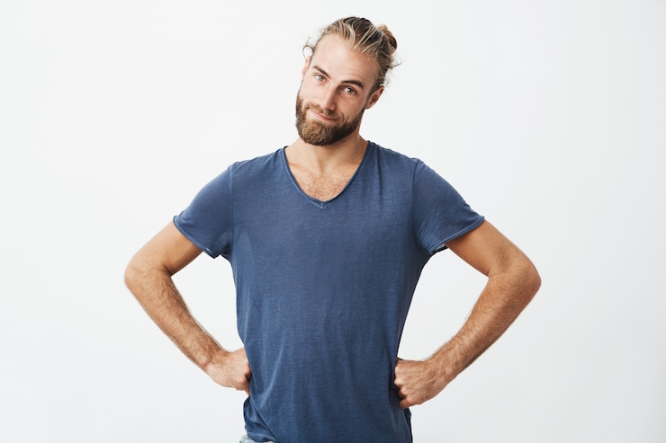 Foto grátis homem bonito engraçado com corte de cabelo na moda e barba de mãos dadas na cintura