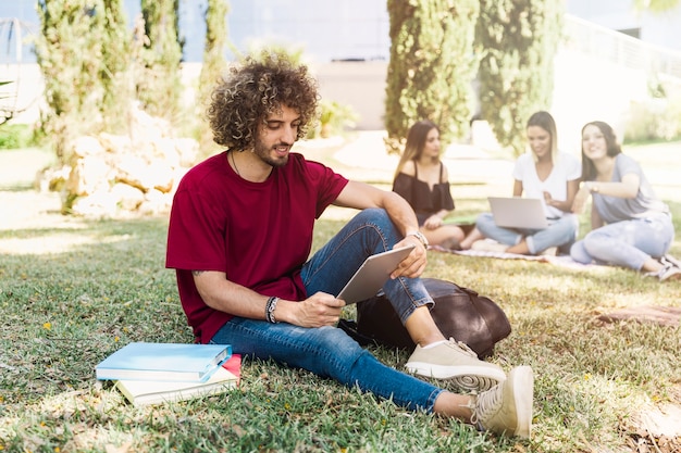 Foto grátis homem bonito, estudando com tablet no parque