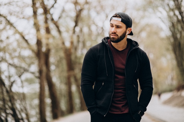 Homem bonito, exercitando-se no parque em roupas esportivas