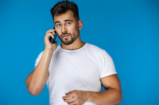 Foto grátis homem bonito fala por telefone e parece perdido