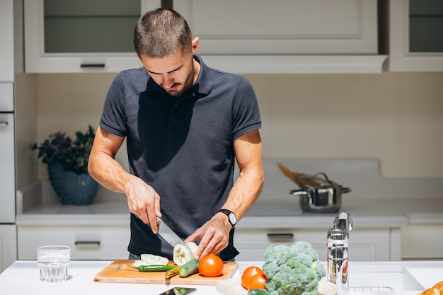 Homem bonito, fazendo o café da manhã na cozinha