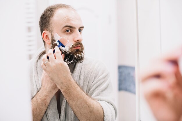 Homem bonito, fazer a barba na manhã