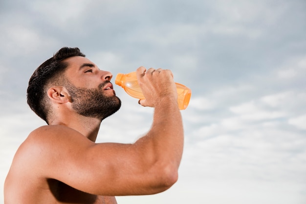 Homem bonito, hidratante após esporte de manhã