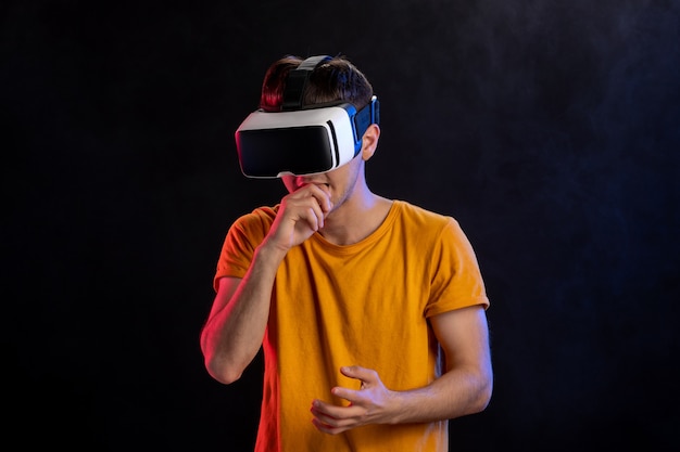 Homem bonito jogando jogo de luta em VR na superfície escura