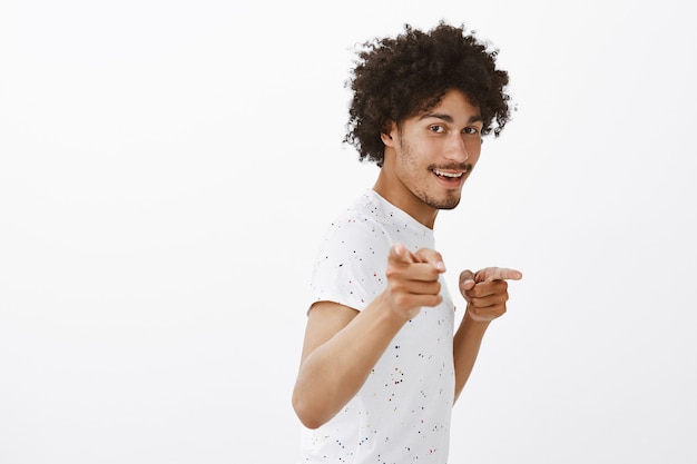 Homem bonito jovem atrevido apontando o dedo, gesto de parabéns, elogiando o bom trabalho, elogio