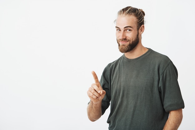 Homem bonito jovem hippie apontando com o dedo