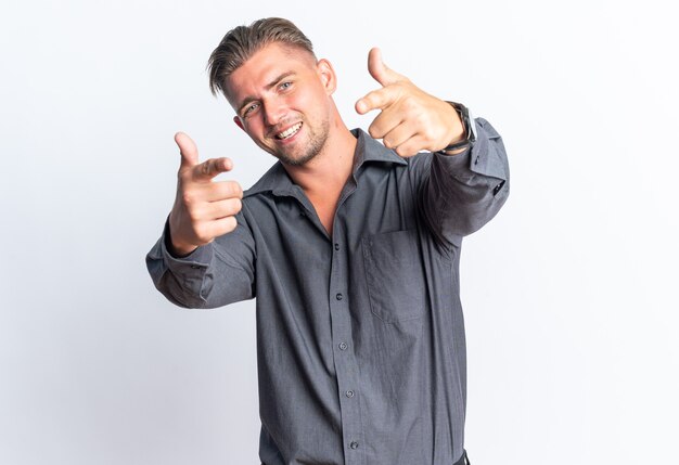 Homem bonito loiro sorridente apontando para a frente