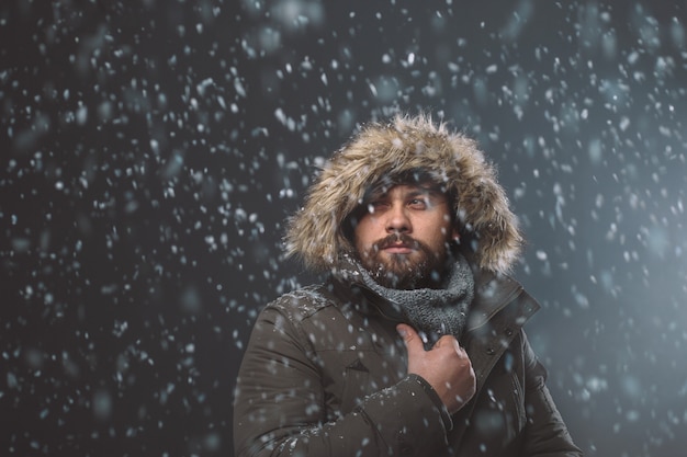 Homem bonito na tempestade de neve