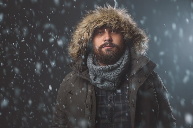 Homem bonito na tempestade de neve