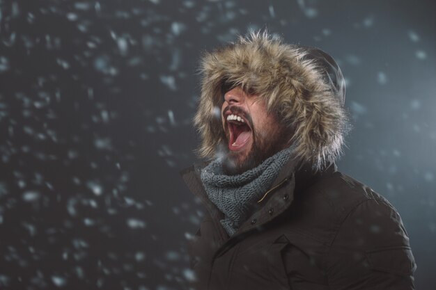 Homem bonito na tempestade de neve