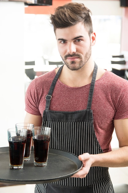 Foto grátis homem bonito oferecendo bebidas no bar