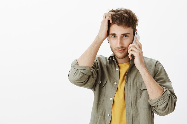 Homem bonito posando com smartphone no estúdio