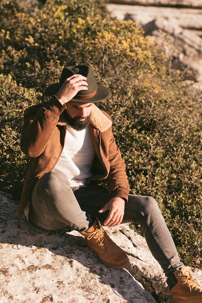 Homem bonito, posando de moda na natureza