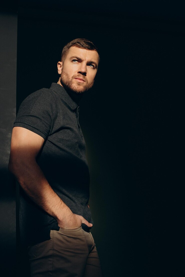 Foto grátis homem bonito posando no estúdio nas sombras