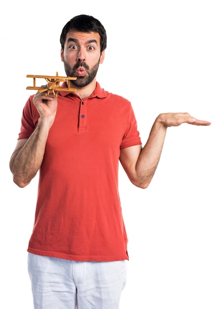 Homem bonito segurando um avião de brinquedo de madeira