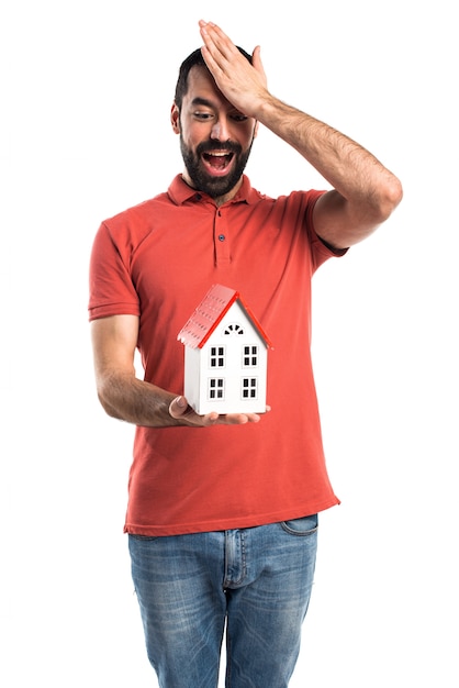 Homem bonito segurando uma casa pequena