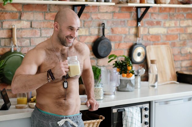 Homem bonito sem camisa na cozinha