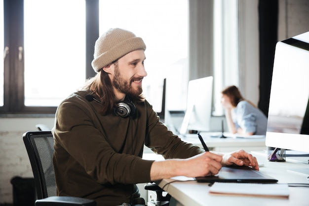 Homem bonito trabalhar no escritório, usando o computador.