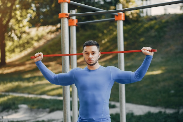 Homem bonito, treinando em um parque de verão