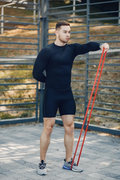 Homem bonito, treinando em um parque de verão