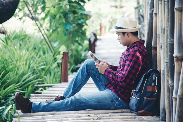 Homem bonito usando laptop na natureza viagens