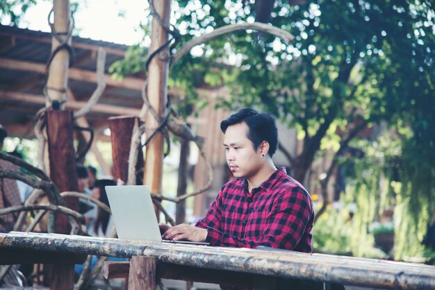 Homem bonito usando laptop na natureza viagens