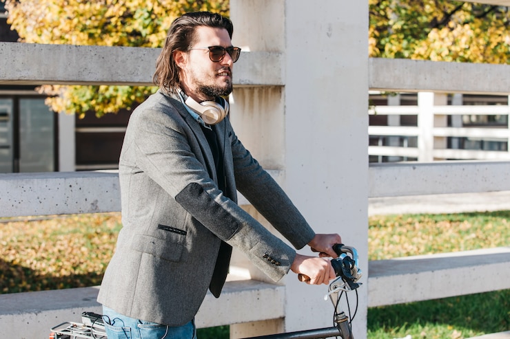 Foto grátis homem bonito, usando óculos de sol, andar de bicicleta