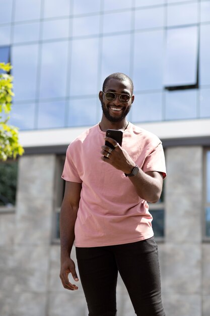 Homem bonito usando smartphone moderno ao ar livre