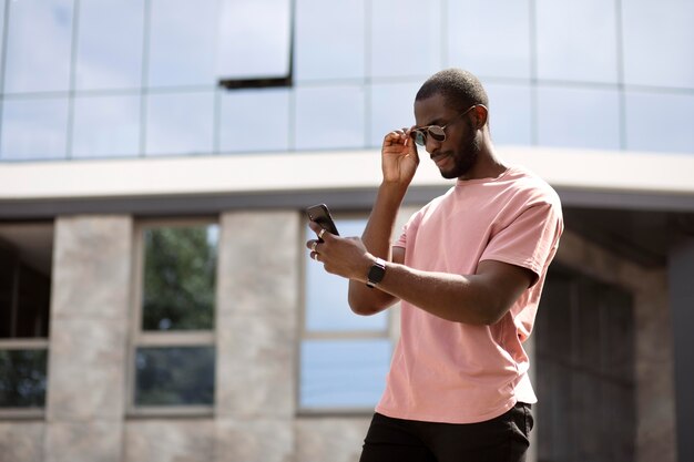 Homem bonito usando smartphone moderno ao ar livre