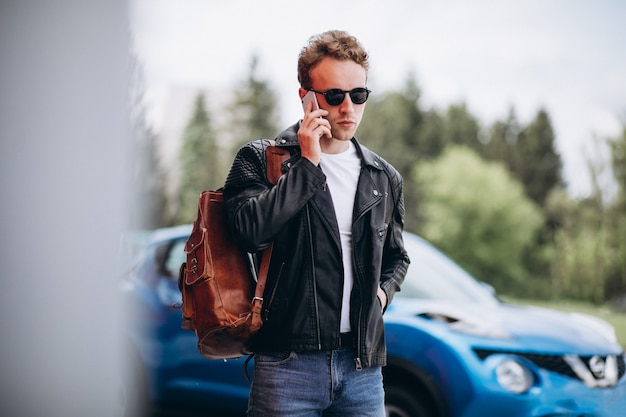 Foto grátis homem bonito, usando telefone pelo carro