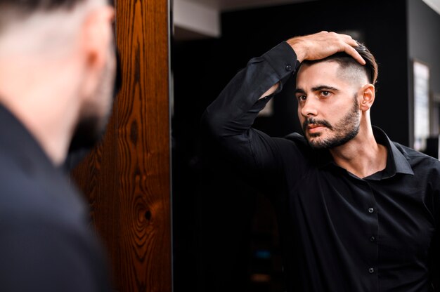 Homem bonito, verificando seu novo estilo de cabelo