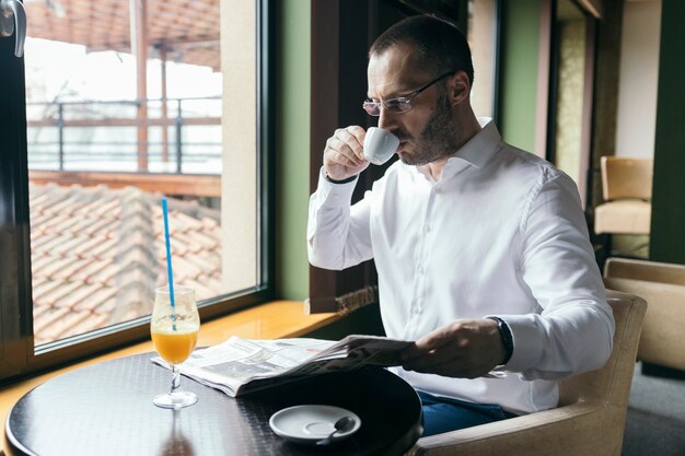 Homem, café bebendo, e, jornal leitura