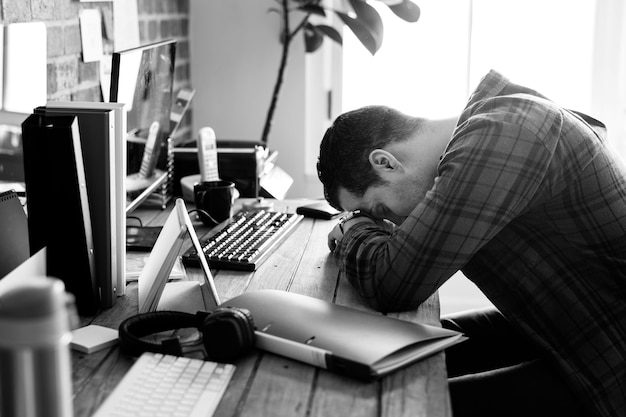 Homem cansado cochilando na mesa de trabalho