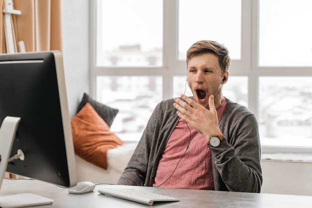 Foto grátis homem cansado de tiro médio na mesa