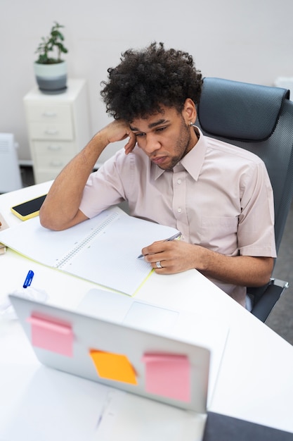 Homem cansado de tiro médio tomando notas