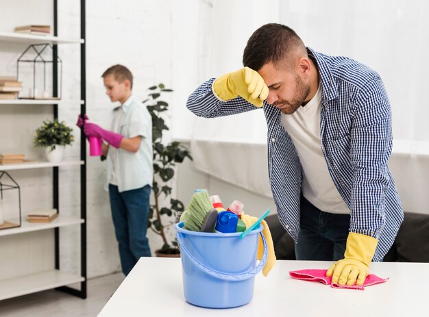 Homem cansado depois de limpar a casa