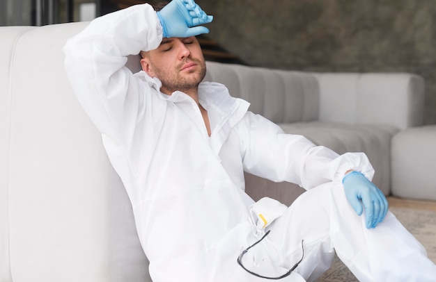 Foto grátis homem cansado, sentado em traje de proteção