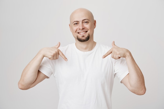 Homem careca feliz e orgulhoso de meia-idade apontando para si mesmo e sorrindo