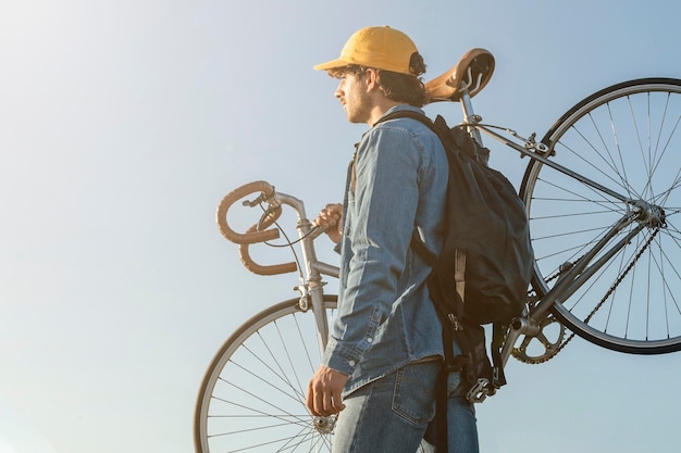 Homem carregando bicicleta, tiro médio