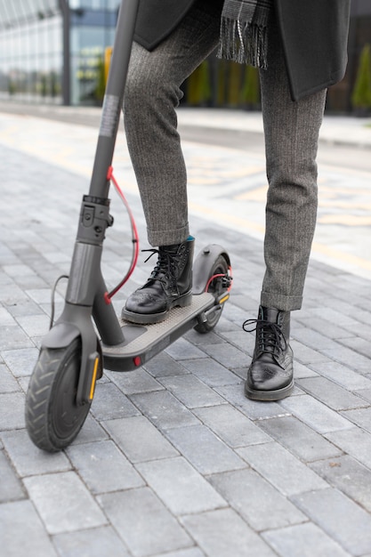 Homem casual posando com sua scooter elétrica