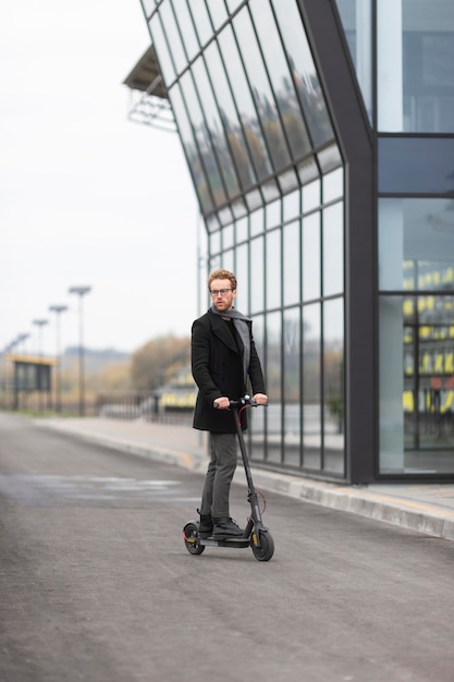 Foto grátis homem casual posando com uma scooter elétrica