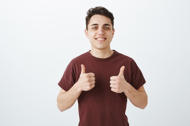 Homem caucasiano feliz e bonito em roupa casual com o polegar para cima